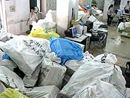 Bưu phẩm chất đống trong phòng khai thác của EMS. Khách đến... đòi bưu phẩm, nhân viên công ty sẽ đi lục tìm từ những đống chất chồng như thế này.