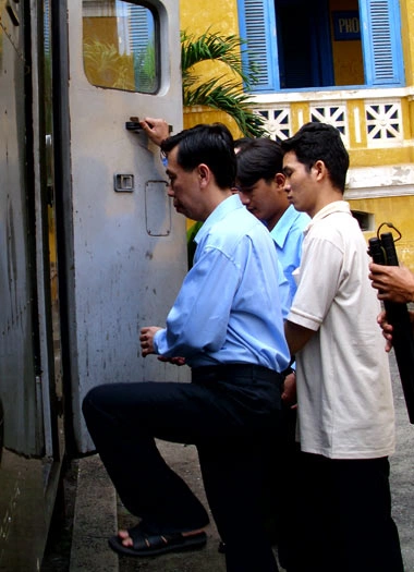 Trí và đồng bọn bước lên xe tù. Ảnh: Tá Lâm.
