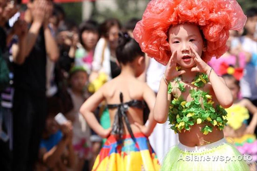 Em bé đội lên đầu bộ tóc giả bằng nilon.