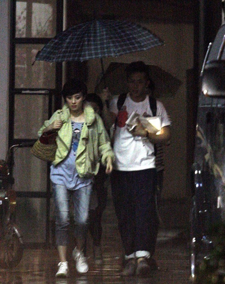 Tôn Lệ, Đặng Siêu bị bắt gặp tại một cửa hàng ở Thượng Hải hôm 6/6. Trong khi vợ bước ra ô tô, Đặng Siêu vội vã theo sau che ô,