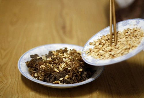 Nếu ăn liền, bạn có thể trộn thịt bò, lạc luôn. Nếu chưa ăn ngay, bạn chỉ nên trộn hoa chuối với nước dùng trước.