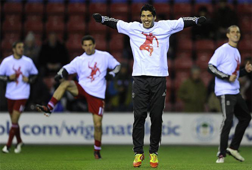 Các cầu thủ Liverpool mặc áo có in hình Suarez trong buổi tập trước trận gặp Wigan mới đây. Các cầu thủ Liverpool mặc áo có in hình Suarez trong buổi tập trước trận gặp Wigan mới đây.