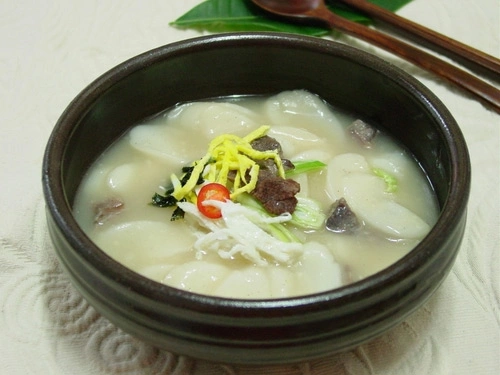 Canh Tteokguk với những chiếc bánh nhỏ hình trắng, nước dùng từ xương bò hầm. Canh Tteokguk với những chiếc bánh nhỏ hình trắng, nước dùng từ xương bò hầm.