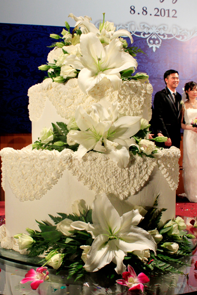 Bánh cưới là chi tiết tạo điểm nhấn với màu trắng tinh khiết, được điểm xuyết thêm những bông hoa lys xinh. Bánh cưới là chi tiết tạo điểm nhấn với màu trắng tinh khiết, được điểm xuyết thêm những bông hoa lys xinh.