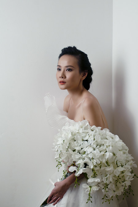 Sử dụng hoa cầm tay bằng lan trắng trên nền váy cưới, cô dâu đẹp mong manh. Sử dụng hoa cầm tay bằng lan trắng trên nền váy cưới, cô dâu đẹp mong manh.