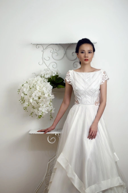 Váy cưới ren cổ thuyền, với những đường cúp tinh tế và đính ren khéo léo, tôn dáng người mặc. Váy cưới ren cổ thuyền, với những đường cúp tinh tế và đính ren khéo léo, tôn dáng người mặc.