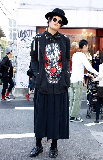 Here's a stylish 20-year-old guy in Harajuku wearing a Givenchy top with a scary clown print, a maxi-skirt, round glasses and a felt hat. His backpack, which you can't see well in this picture, is from the hip Japanese brand Homeless Party. M Here's a stylish 20-year-old guy in Harajuku wearing a Givenchy top with a scary clown print, a maxi-skirt, round glasses and a felt hat. His backpack, which you can't see well in this picture, is from the hip Japanese brand Homeless Party. M