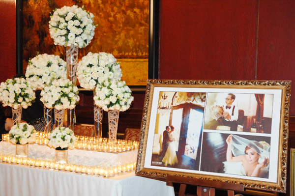 Góc phải của bàn đón tiếp là nhiều bình hoa cao được kết từ hoa hồng và lan tường cùng hàng trăm ngọn nến lung linh. Cạnh đó là tấm ảnh cưới phóng của đôi uyên ương. Góc phải của bàn đón tiếp là nhiều bình hoa cao được kết từ hoa hồng và lan tường cùng hàng trăm ngọn nến lung linh. Cạnh đó là tấm ảnh cưới phóng của đôi uyên ương.