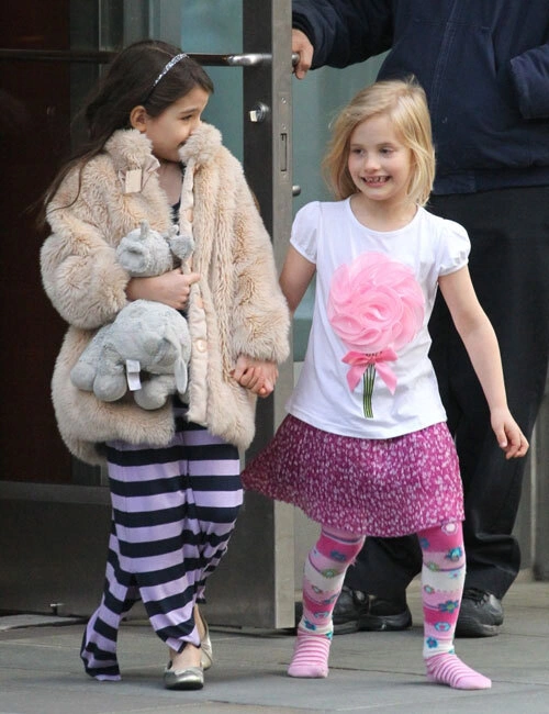 Suri Cruise nắm chặt tay cô bạn khi ra khỏi một tòa nhà ở New York hôm 10/3. Suri Cruise nắm chặt tay cô bạn khi ra khỏi một tòa nhà ở New York hôm 10/3.