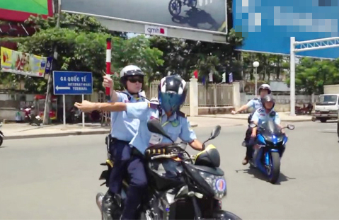 Bảo vệ cưỡi môtô "múa" gậy dẹp đường cho đoàn xe đi qua. Ảnh cắt từ clip Bảo vệ cưỡi môtô "múa" gậy dẹp đường cho đoàn xe đi qua. Ảnh cắt từ clip