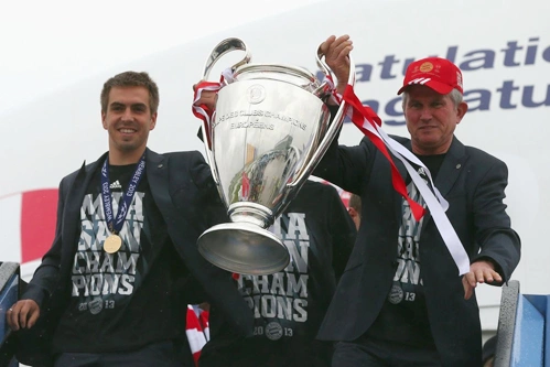 Philipp Lahm và HLV Juup Heynckes cầm Cup đi đầu khi ra khỏi máy bay. Philipp Lahm và HLV Juup Heynckes cầm Cup đi đầu khi ra khỏi máy bay.