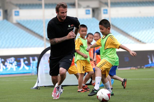 Becks chơi bóng cùng trẻ em Trung Quốc. Ảnh: