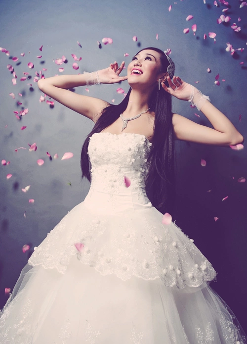 Xen kẽ giữ các tầng váy là lớp vải ren thêu tay hình hoa dây leo tinh tế. Xen kẽ giữ các tầng váy là lớp vải ren thêu tay hình hoa dây leo tinh tế.