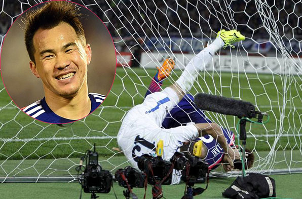 Shinji Okazaki che chắn để bóng tự lăn vào lưới trong nỗ lực truy cản của hậu vệ Uzbekistan. Ảnh: AP.