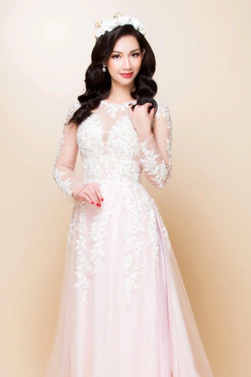 Vẫn với kiểu áo dài trắng lấy cảm hứng từ váy cưới nhưng khi kết hợp cùng một chiếc chân váy lụa dài màu hồng phấn, bạn sẽ có một phong cách thời trang mới: ấn tượng và hợp mốt.