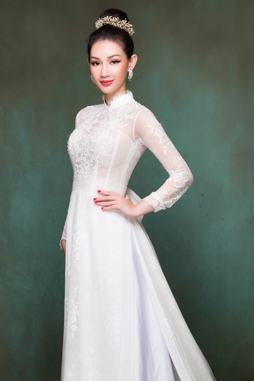 Cô dâu có thể chọn áo không cổ hoặc cổ cao 3 phân viền ren và phần cánh tay bằng vải xuyên thấu, gợi sự liên tưởng đến vẻ đẹp mong manh của bông hoa buổi sớm.