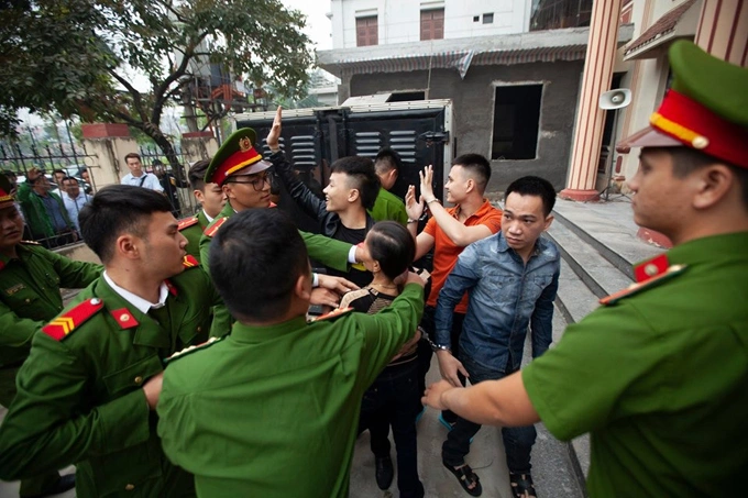 Bước xuống từ xe thùng, Khá Bảnh cười tươi, vẫy tay chào người thân đứng bên ngoài. Bà Khánh, mẹ Khá Bảnh, lao vào ôm con buộc lực lượng chức năng can thiệp. Ảnh: Phạm Chiểu.