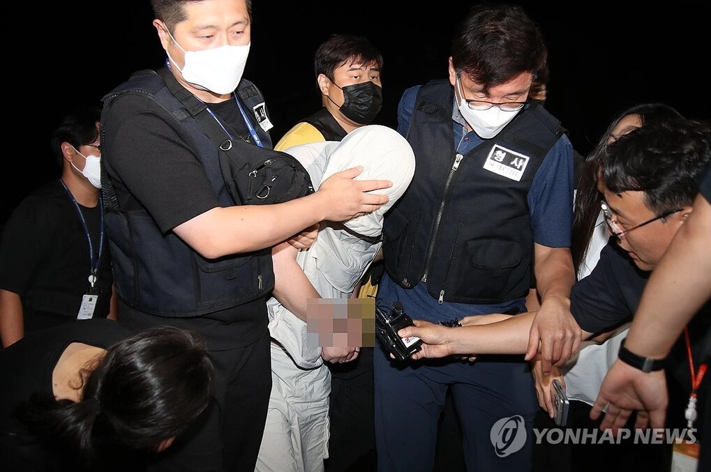 Nghi phạm được dẫn giải đến đồn cảnh sát Gyeongsan. Ảnh: Yonhap News