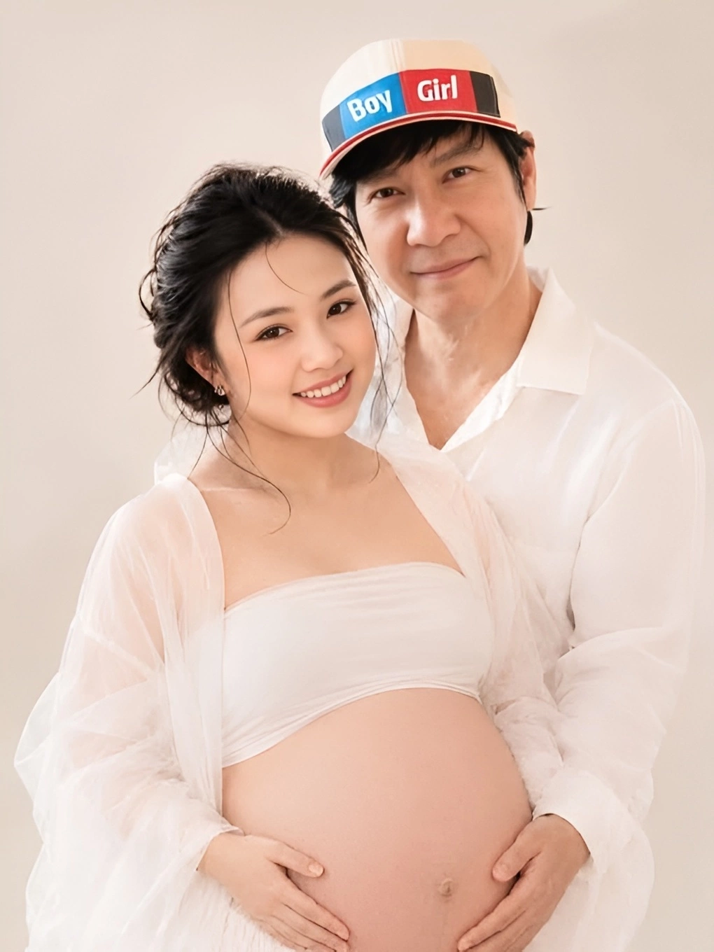 ベビーシャワーで、男児と女児の表示が付いた帽子をかぶるレ・フインと妊娠中の妻ミー・リン